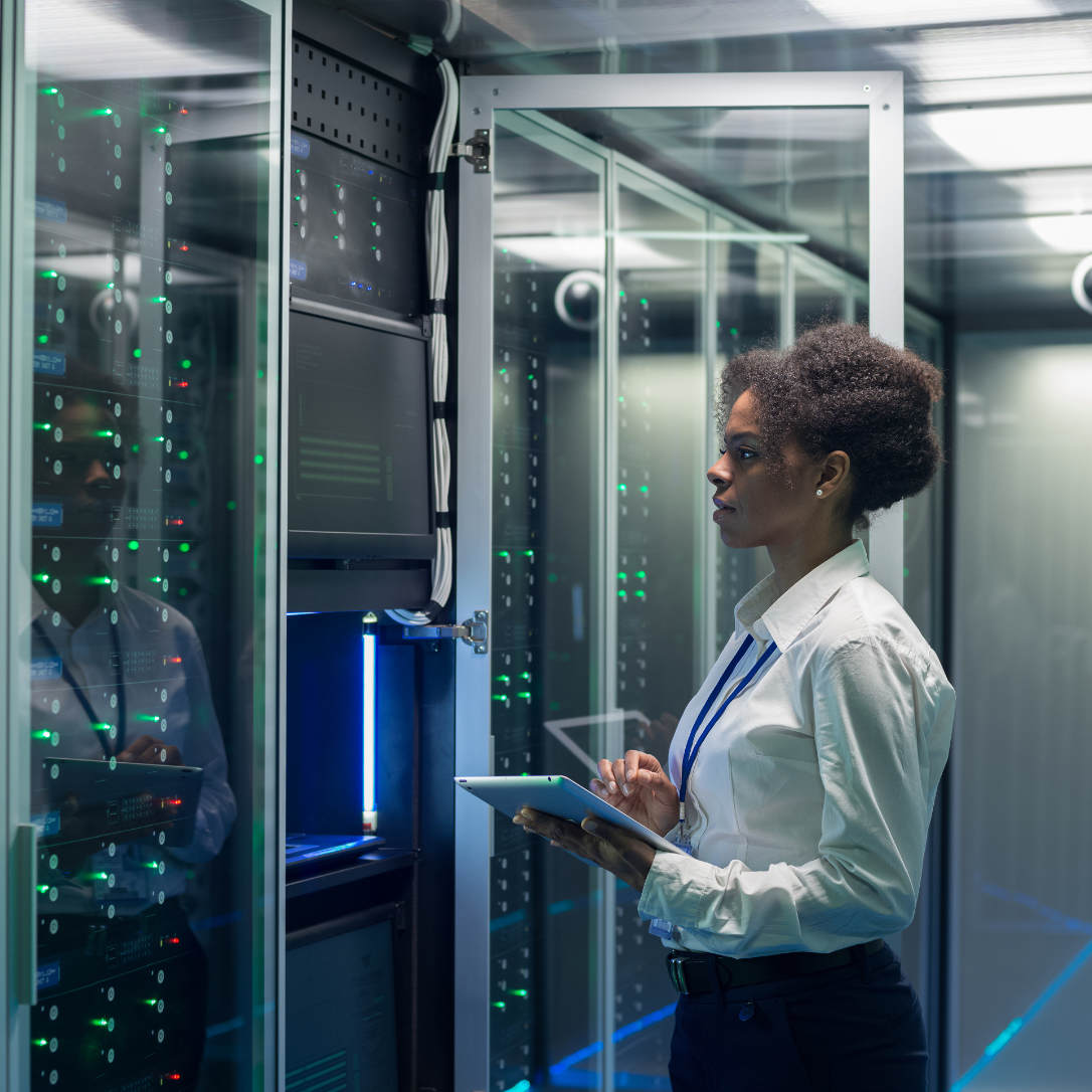 Female technician works on a tablet in a data center